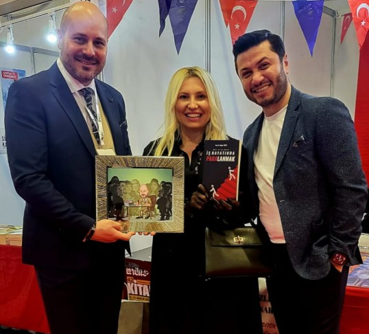 BİR ETKİNLİKTE KARİKATÜR YAZAR HEDİYESİ ALIRKEN...